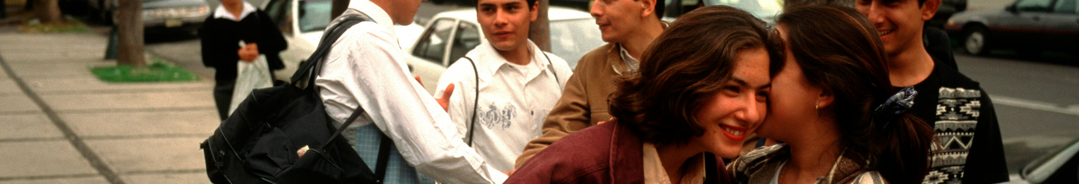 A group of young people on an urban street, talking and smiling